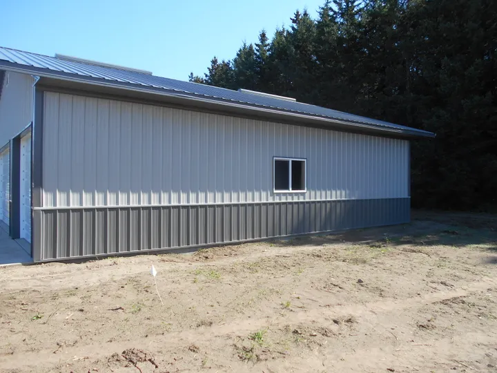 Gray exterior wainscot band on a light steel building